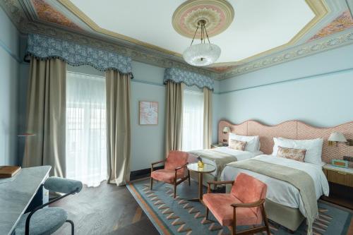 a bedroom with two beds and a table and chairs at Stradom House, Autograph Collection in Kraków