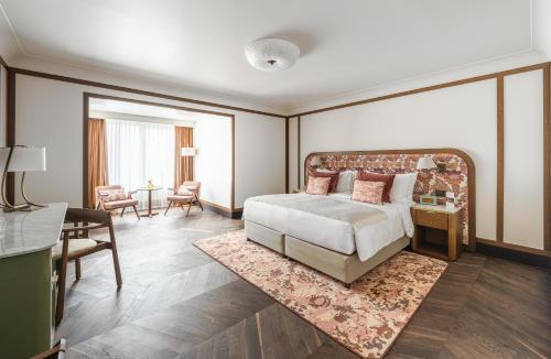a bedroom with a large bed and a living room at Stradom House, Autograph Collection in Kraków