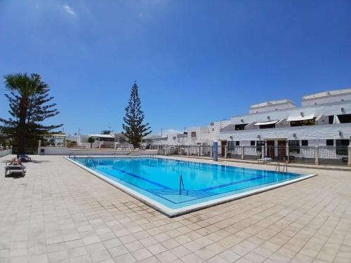 een groot zwembad voor een gebouw bij Papaya in Costa Del Silencio