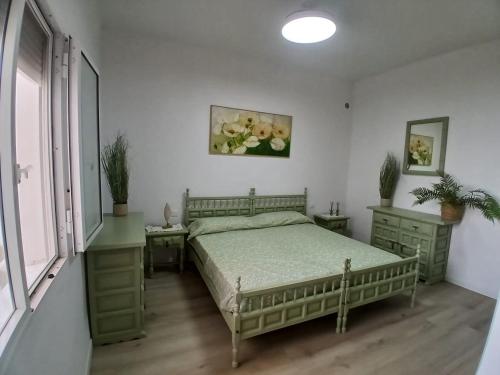 een slaapkamer met een bed, twee tafels en een raam bij Papaya in Costa Del Silencio