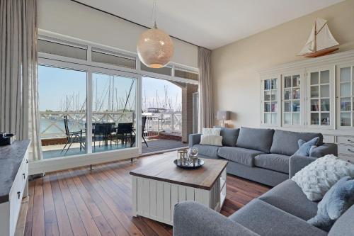 a living room with a couch and a table at Kabbelaarsbank 405 - Port Marina Zélande NOT INTENDED FOR COMPANY OR WORK-RELATED STAYS in Ouddorp