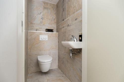 a bathroom with a toilet and a sink at Kabbelaarsbank 405 - Port Marina Zélande NOT INTENDED FOR COMPANY OR WORK-RELATED STAYS in Ouddorp
