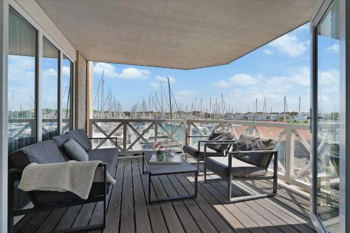 a balcony with chairs and a table and a view of a harbor at Kabbelaarsbank 411 - Port Marina Zélande NOT INTENDED FOR COMPANY OR WORK-RELATED STAYS in Ouddorp