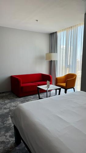 a hotel room with a bed and a red couch at ibis Styles Warszawa City in Warsaw