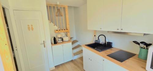 a small kitchen with white cabinets and a sink at Plein cœur centre historique de Charlieu avec parking et garage vélo moto in Charlieu