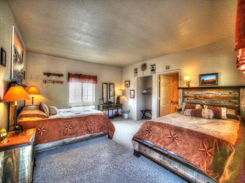a large bedroom with two beds and a television at Stagecoach Trails Guest Ranch in Yucca