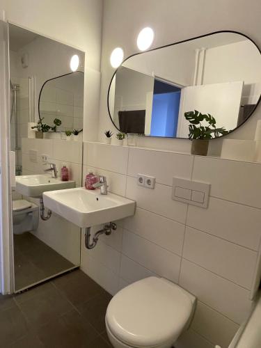 a bathroom with a toilet and a sink and a mirror at Skyline City Apartment in Berlin