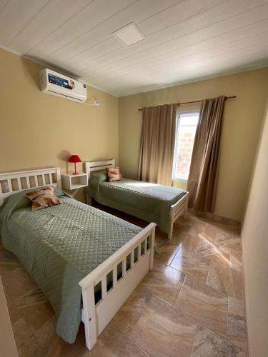 une chambre avec deux lits et une fenêtre dans l'établissement Bungalows Casa Mansa 1 y 2, à Villa Elisa