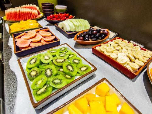 a table topped with different types of fruits and vegetables at Novotel Porto Alegre Airport in Porto Alegre