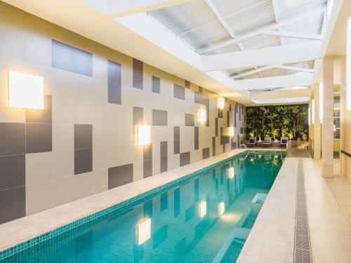 a swimming pool in a building with a ceiling at Novotel Porto Alegre Airport in Porto Alegre