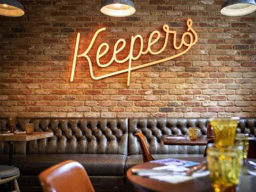 a neon sign that says keller on a brick wall at Mercure Oxford Eastgate Hotel in Oxford