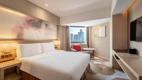 a hotel room with a white bed and a window at Holiday Inn Kunming City Centre by IHG in Kunming