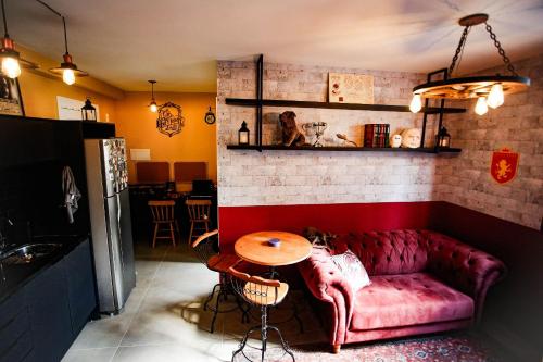 Una sala de estar con un sofá rojo y una mesa. en Apartamento Temático de Harry Potter, en São Paulo