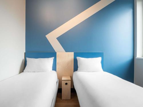 two beds sitting next to each other in a room at ibis budget Leuven Centrum in Leuven