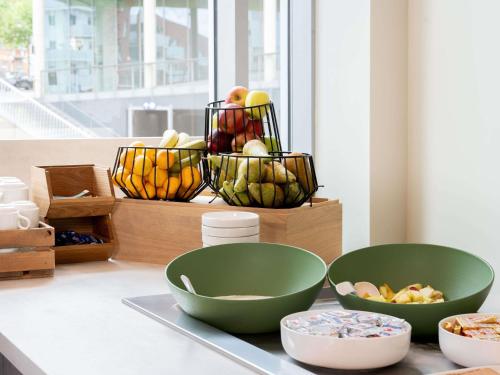 a group of bowls sitting on a counter next to a window at ibis budget Leuven Centrum in Leuven