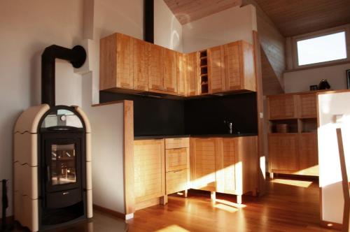 a kitchen with wooden cabinets and a stove at Mokaito Namai in Sadžiūnai