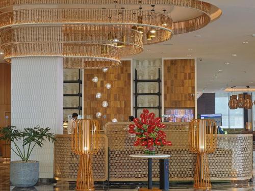 a restaurant with a table and chairs and chandeliers at Novotel Hyderabad Airport in Hyderabad
