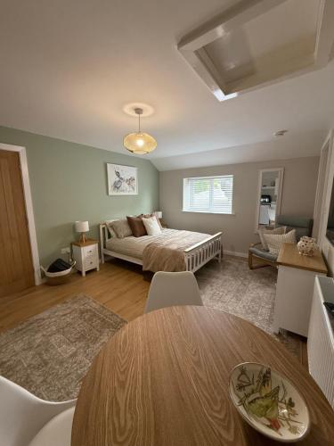 a living room with a bed and a table at The Annexe at Kirtonia in Lydford