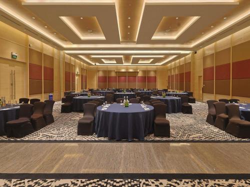 a large banquet hall with tables and chairs at Novotel Hyderabad Airport in Hyderabad
