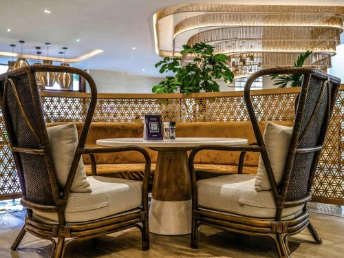 a table and two chairs in a restaurant at Novotel Hyderabad Airport in Hyderabad