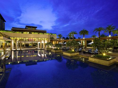 a resort with a large swimming pool at night at Novotel Hyderabad Airport in Hyderabad