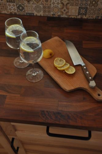 a wooden cutting board with a glass of water and a knife at Mokaito Namai in Sadžiūnai