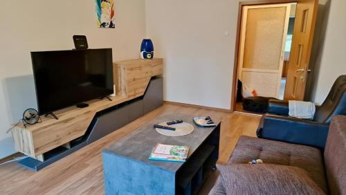 a living room with a couch and a flat screen tv at Stylish Apt, Free Parking, Near Center & Airport in Varna City