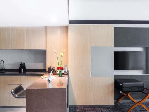 a kitchen with a counter and a television in it at Grand Mercure Shanghai Hongqiao in Shanghai