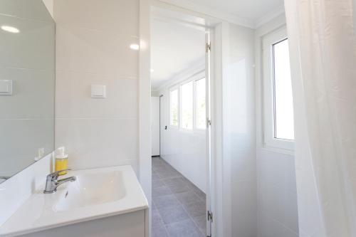 Un baño blanco con lavabo y ducha. en Casa da Vizinha, en Lisboa