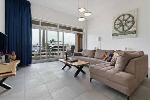 a living room with a couch and a table at Kabbelaarsbank 504 - Port Marina Zélande in Ouddorp
