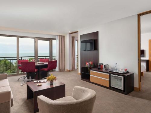 a living room with a room with a couch and a table at Novotel Trabzon in Trabzon