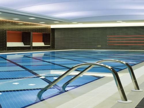 an indoor swimming pool with blue tile walls and a pooliterator at Novotel Trabzon in Trabzon