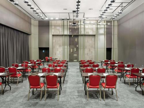 a conference room with red chairs and tables at Novotel Trabzon in Trabzon