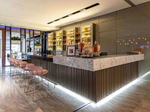 a bar with a row of stools in a restaurant at Novotel Trabzon in Trabzon