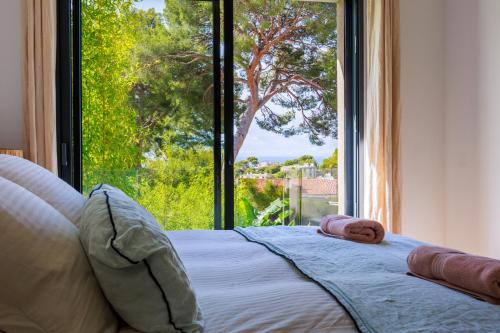 una camera da letto con un letto con una grande finestra di Villa Cosy Neuve 8 min à pieds des plages a Cassis