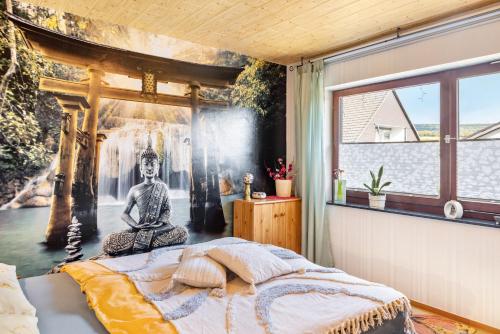 a bedroom with a wall mural of a buddha at Ferienwohnung Energie und Balance in Lichtenau