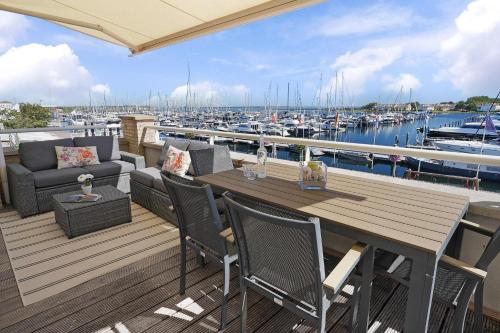 a wooden deck with a table and chairs and a marina at Kabbelaarsbank 512 - Port Marina Zélande in Ouddorp