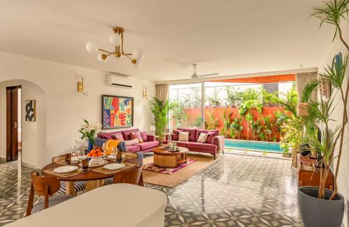 a living room with pink couches and a table at El Volar by The Blue Kite - 2BHK, 5 Mins to Casino & 10 Mins to Candolim Beach with Big common Pool, Fully Equipped Kitchen, 24x7 Security, WiFi in Nerul