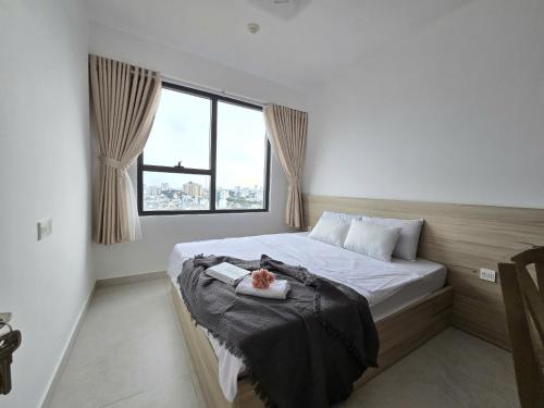 a bed in a room with a large window at SOHO Suites - Saigon Central, 5-Min-To-Bui Vien Street in Ho Chi Minh City