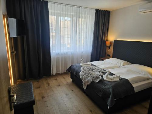 a bedroom with a bed and a large window at PENZION BLANKA - Znojmo in Znojmo