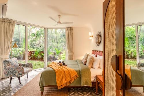 a bedroom with a bed and a large window at El Volar by The Blue Kite - 2BHK, 5 Mins to Casino & 10 Mins to Candolim Beach with Big common Pool, Fully Equipped Kitchen, 24x7 Security, WiFi in Nerul