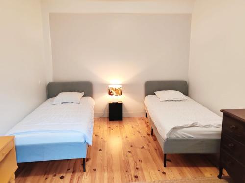 two beds in a room with a wooden floor at Maison chic du Jerzual in Dinan