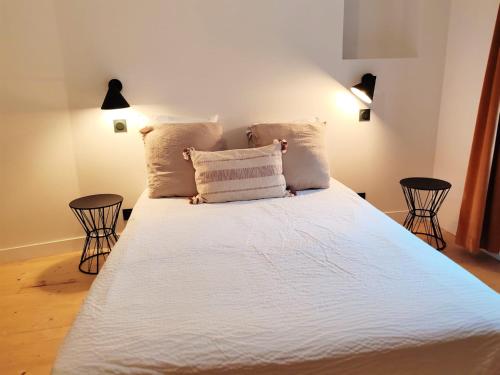 a bedroom with a large bed with white sheets and pillows at Maison chic du Jerzual in Dinan