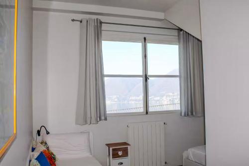 a bedroom with a window and a bed with a radiator at Belvedere ONE in Brezzo
