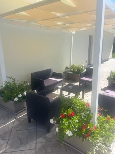 a patio with couches and potted plants and flowers at La casa dei Coloni in Nola