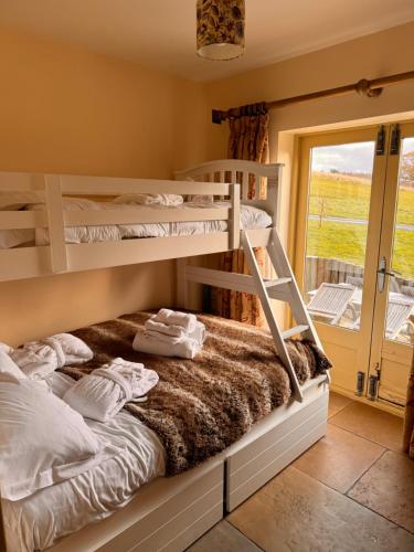 a bedroom with bunk beds and a balcony at Huckleberry Cottage at Black Horse Beamish in Beamish