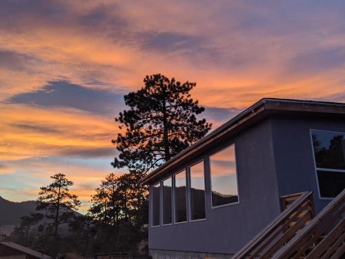 a house with a sunset in the background at Near Red Rocks with Hot Tub, Fire Pit and Views in Indian Hills