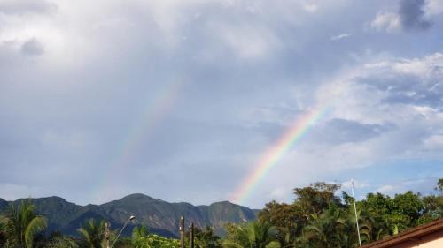 a rainbow in the sky with mountains in the background at Condominio Morada da Praia in Boracéia