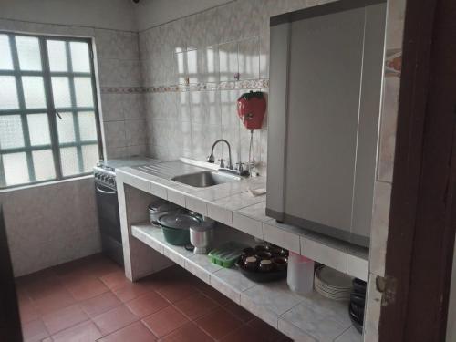a kitchen with a sink and a stove at POSADA VILLA DEL ROSARiO in Sutamarchán
