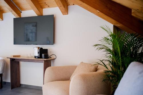 a living room with a couch and a tv on the wall at Sky Room Square View - Bernina Experience in Tirano